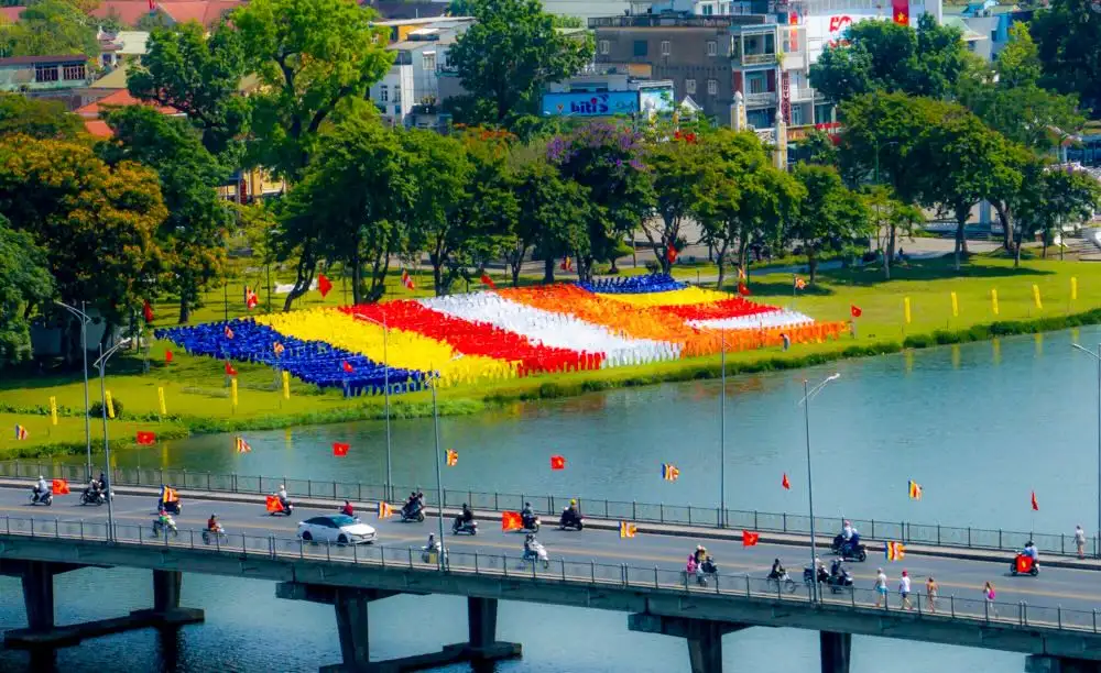 Lá cờ Phật Giáo khổng lồ bên bờ sông Hương - Biểu tượng tâm linh mùa Phật Đản Huế Lá cờ Phật Giáo khổng lồ bên bờ sông Hương – Biểu tượng tâm linh mùa Phật Đản Huế